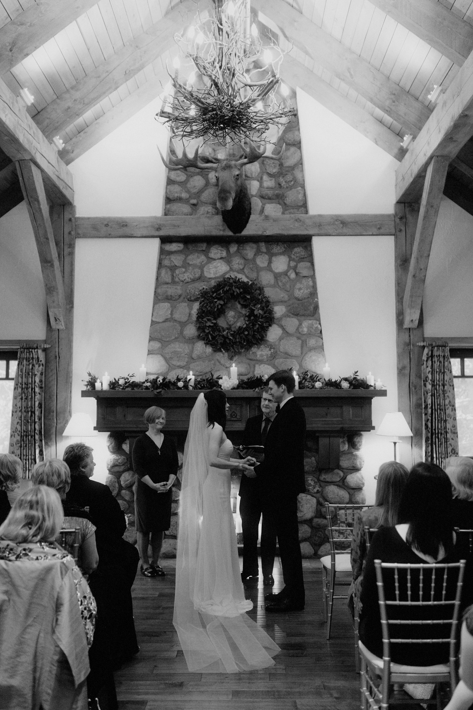 Fireplace wedding ceremony in front of the riverstone fireplace at the Post Hotel library