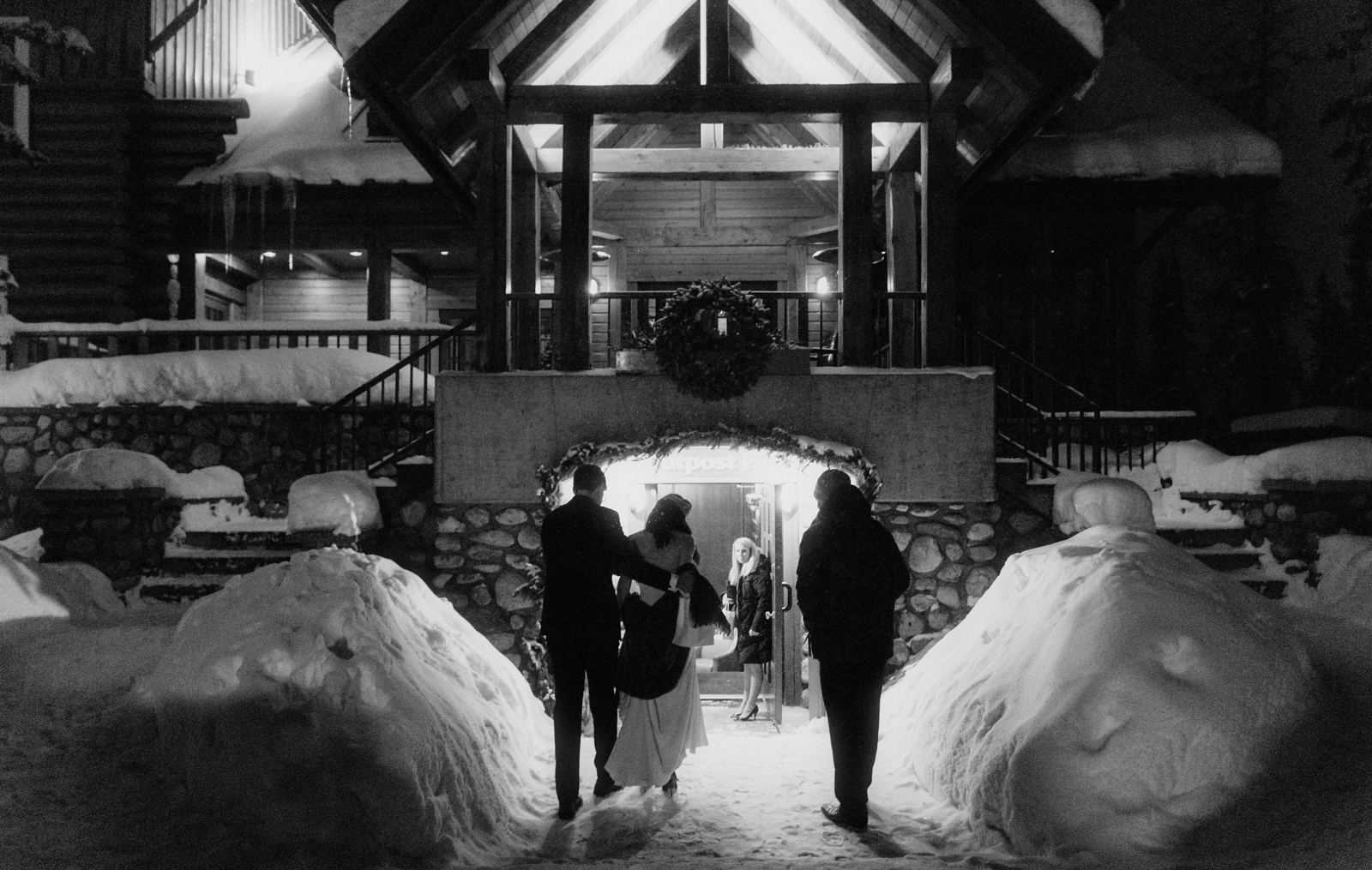 Wedding couple amongst snow drifts heading to their first dance at the Outpost Pub