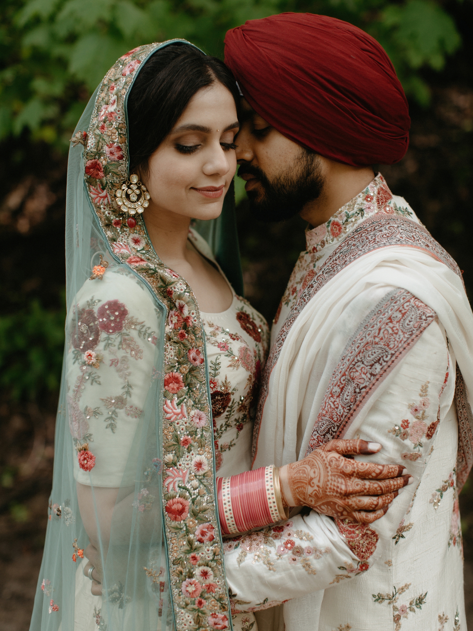Timeless portrait of a bride and groom in lehenga with cream, teal and soft pink hues