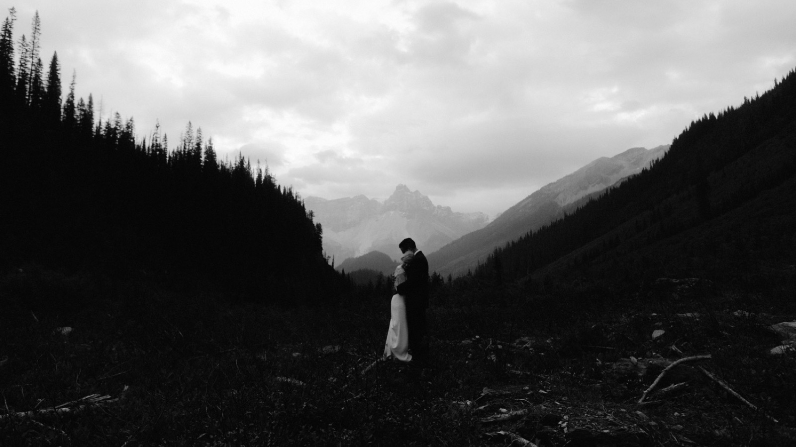 Wedding couple cuddling in an avalanche path in a remote part of Yoho National Park for their day after session
