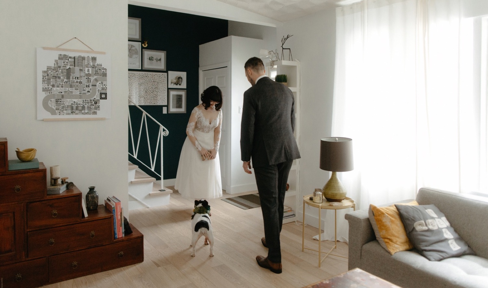 Wedding couple getting ready together in their home with their French bulldog wearing a floral collar