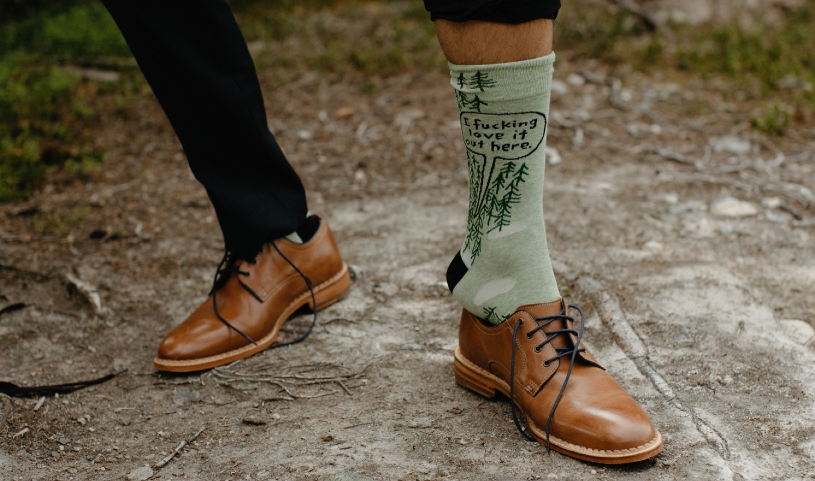 Groom puttin gon green "I fucking love it out here" socks at his backcountry hiking wedding