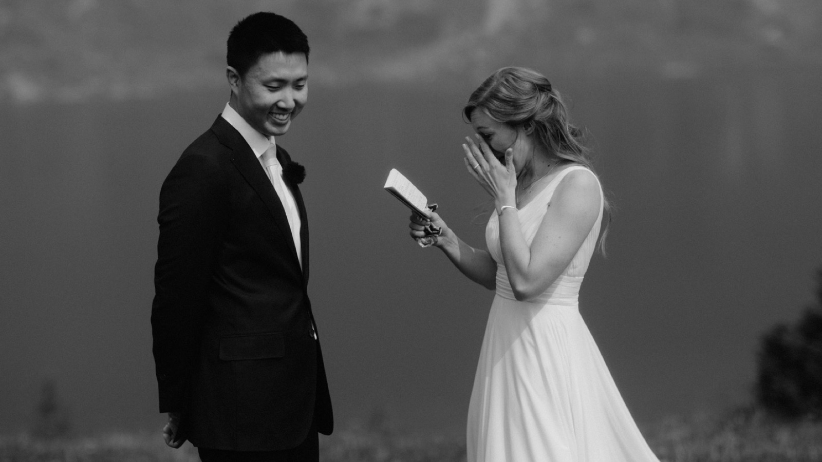 Bride and groom reading handwritten vow books to each other at their adventurous hiking wedding