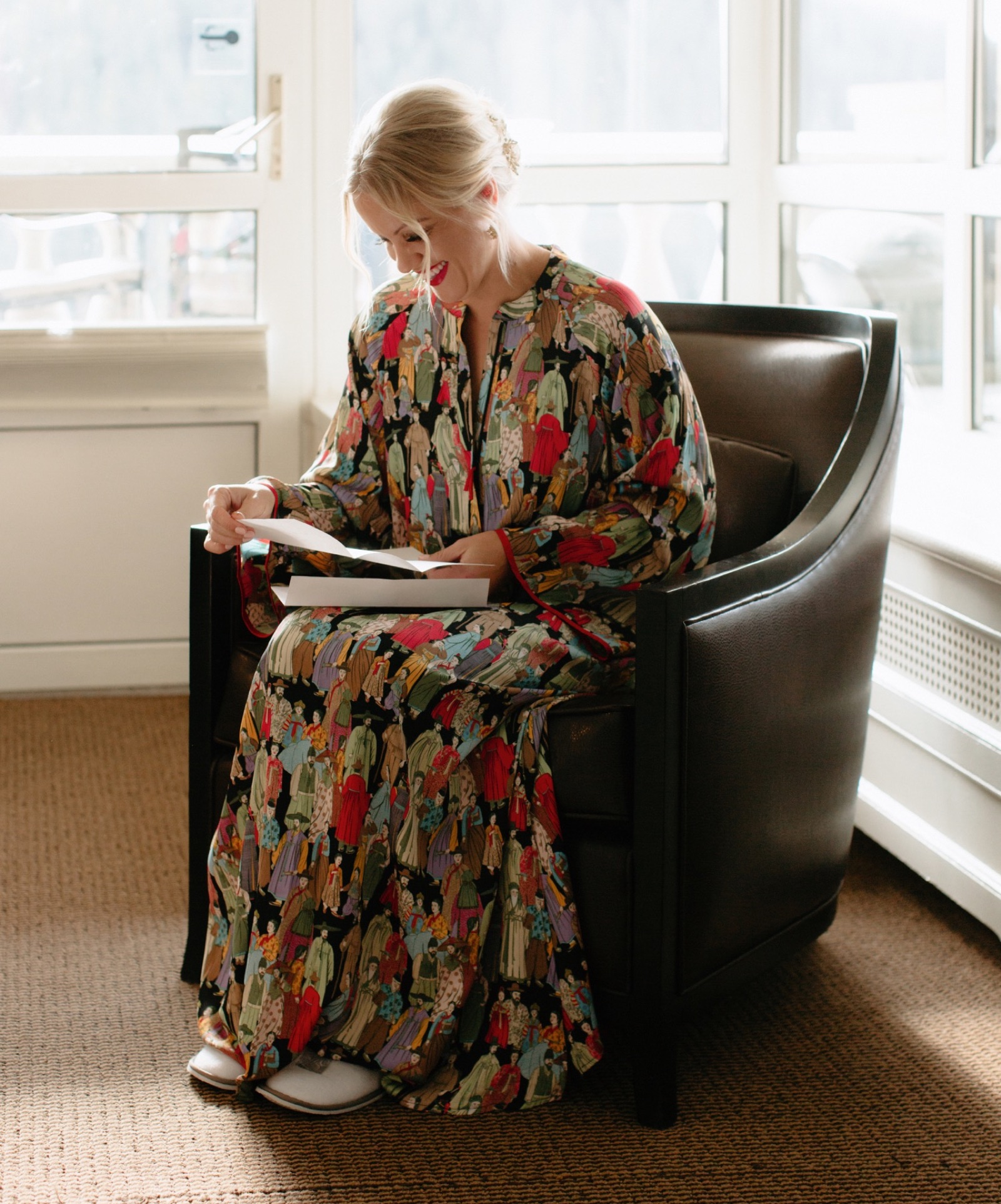 Bride reading a letter from her groom when getting ready in Lake Louise, wearing a unique colourful Japanese robe