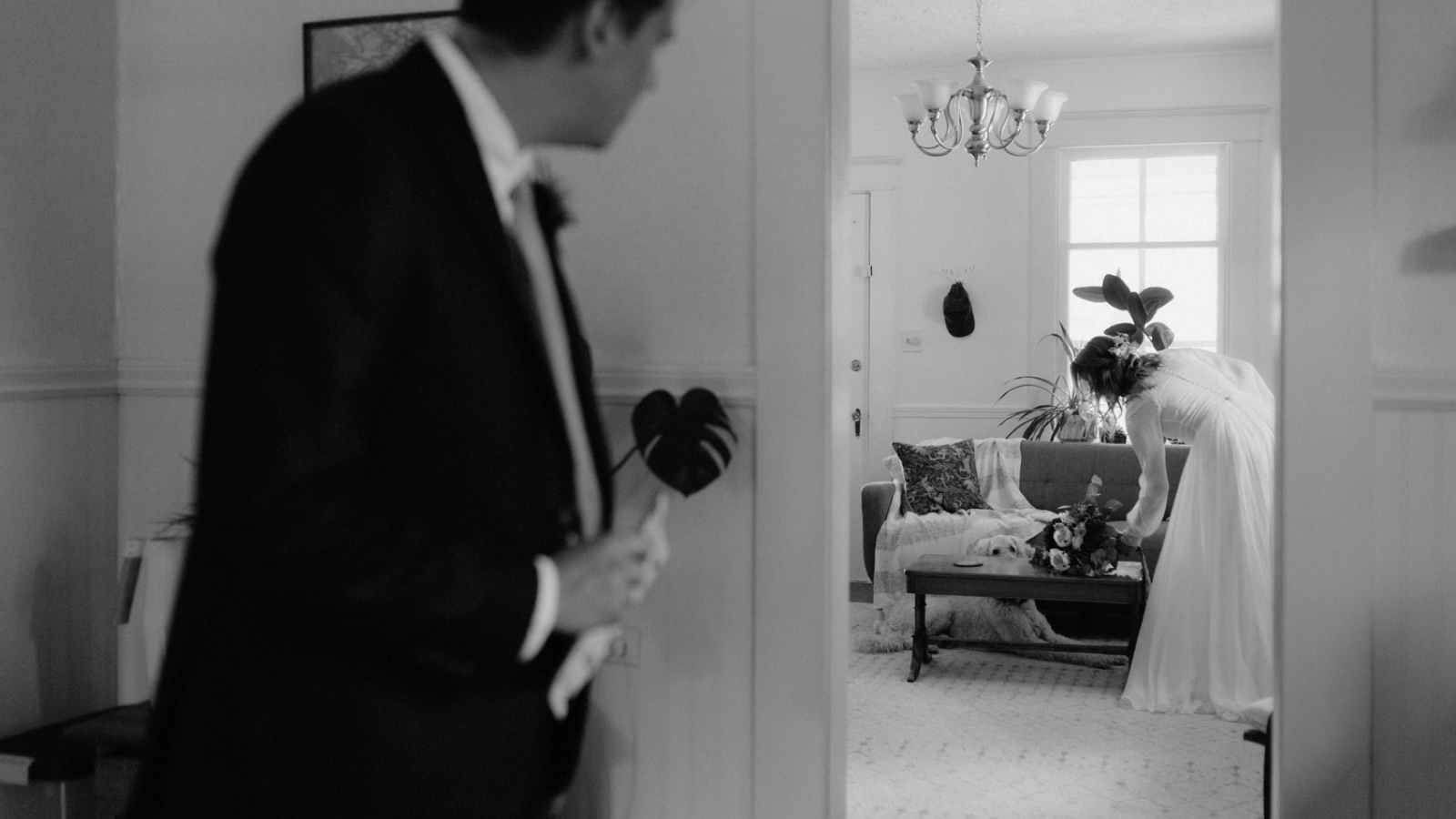 A wedding couple getting ready together in their home with their dog in British Columbia