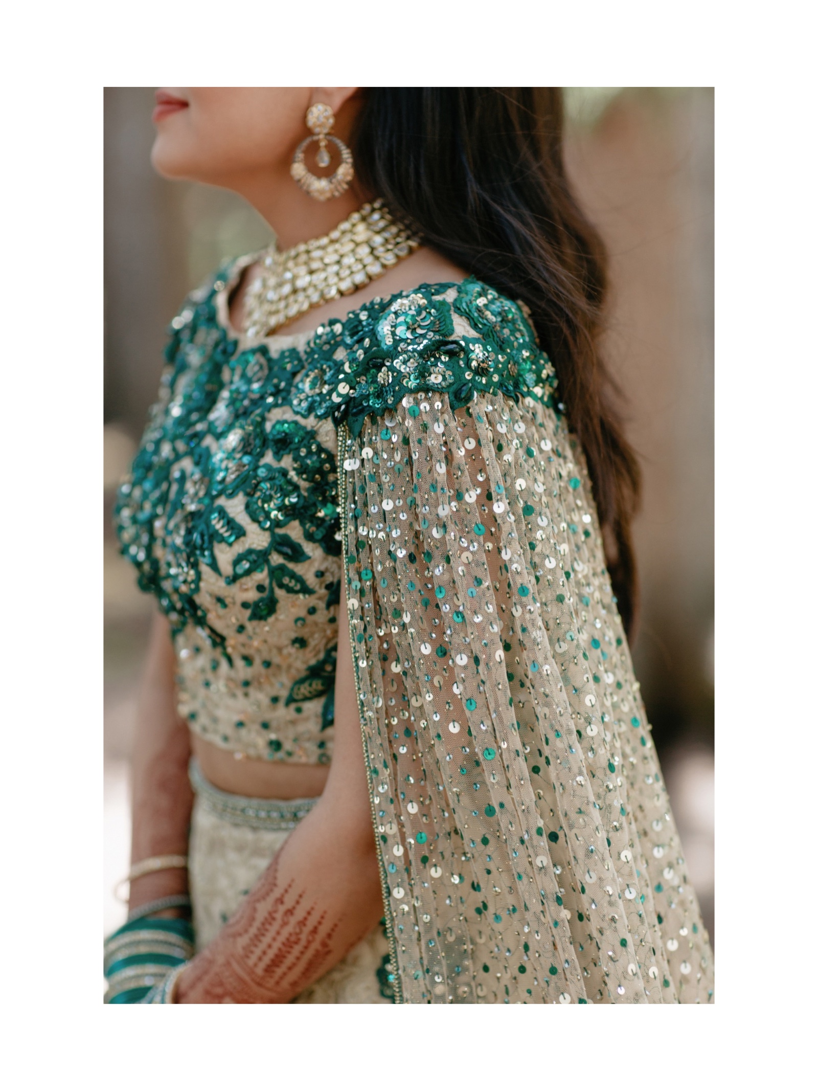 Bride wearing a lehenga cape with emerald and gold sequence in Banff