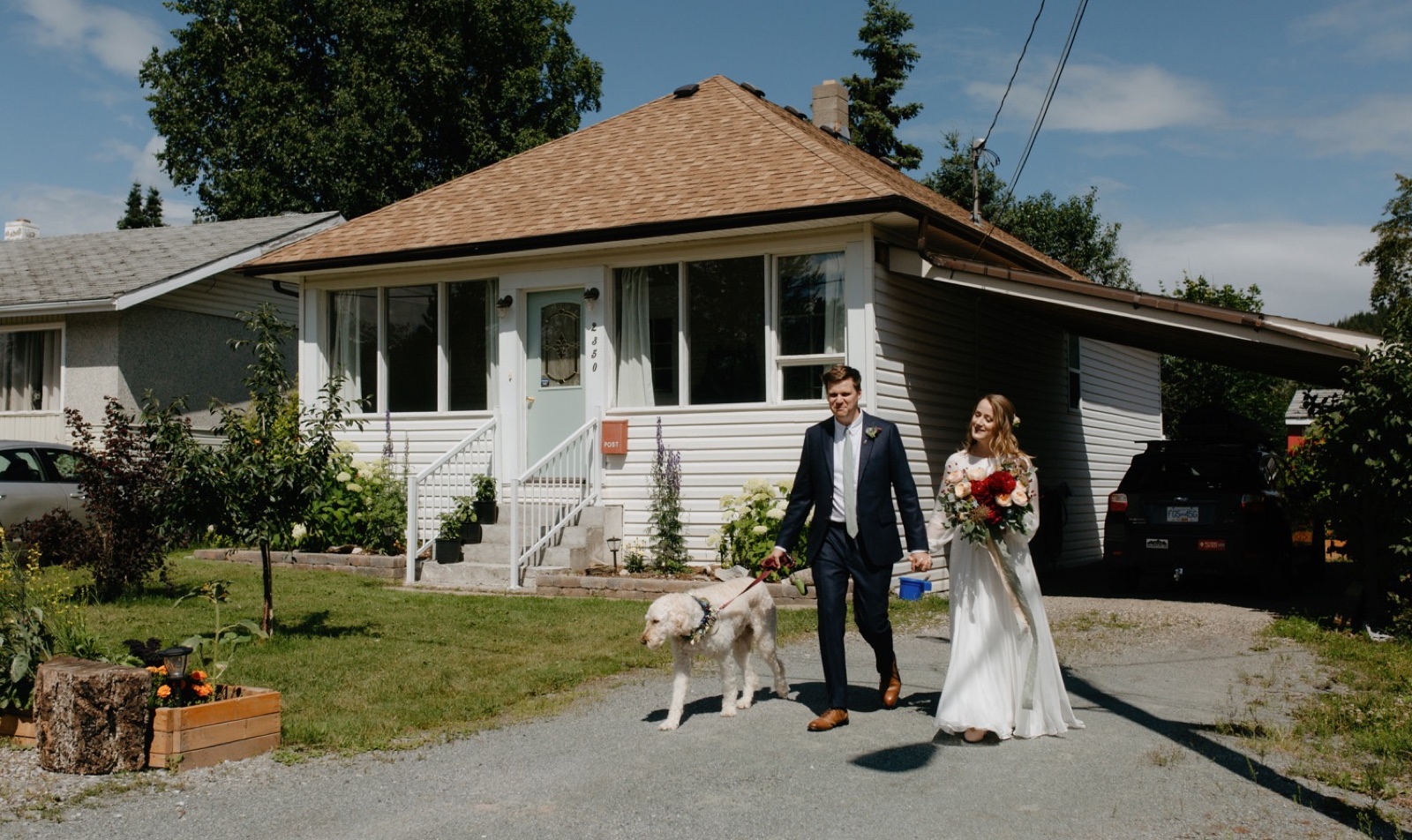 A wedding couple walking from their personal home in Prince George to their park ceremony with their dog