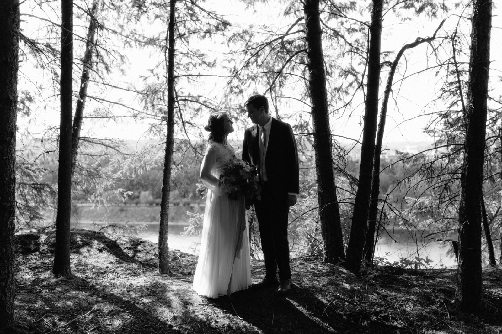 Bride and groom posting for portraits overlooking the Fraser River in Prince George, British Columbia