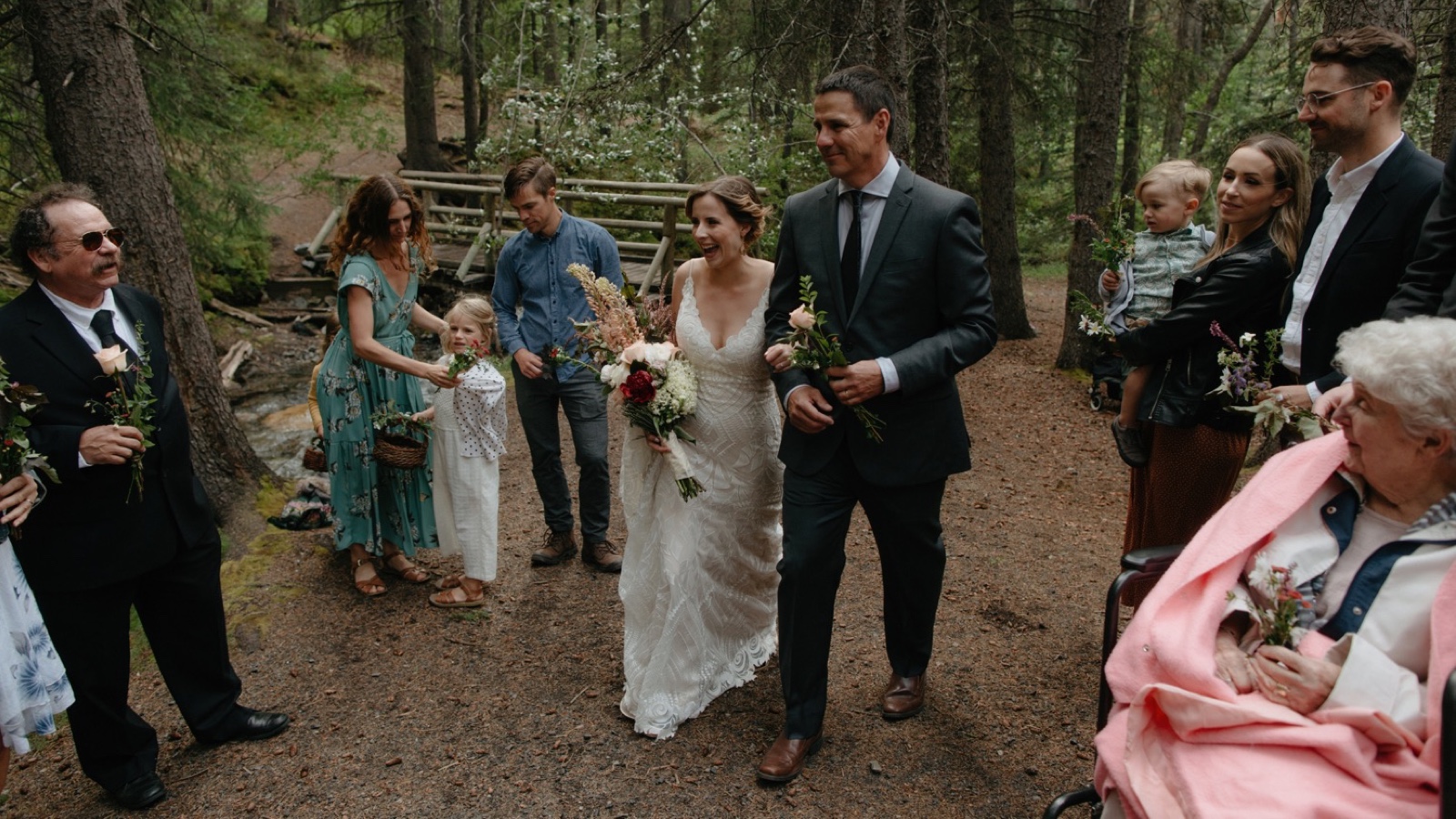 Bride and her father walking up a makeshift aisle for their Banff standing wedding ceremony