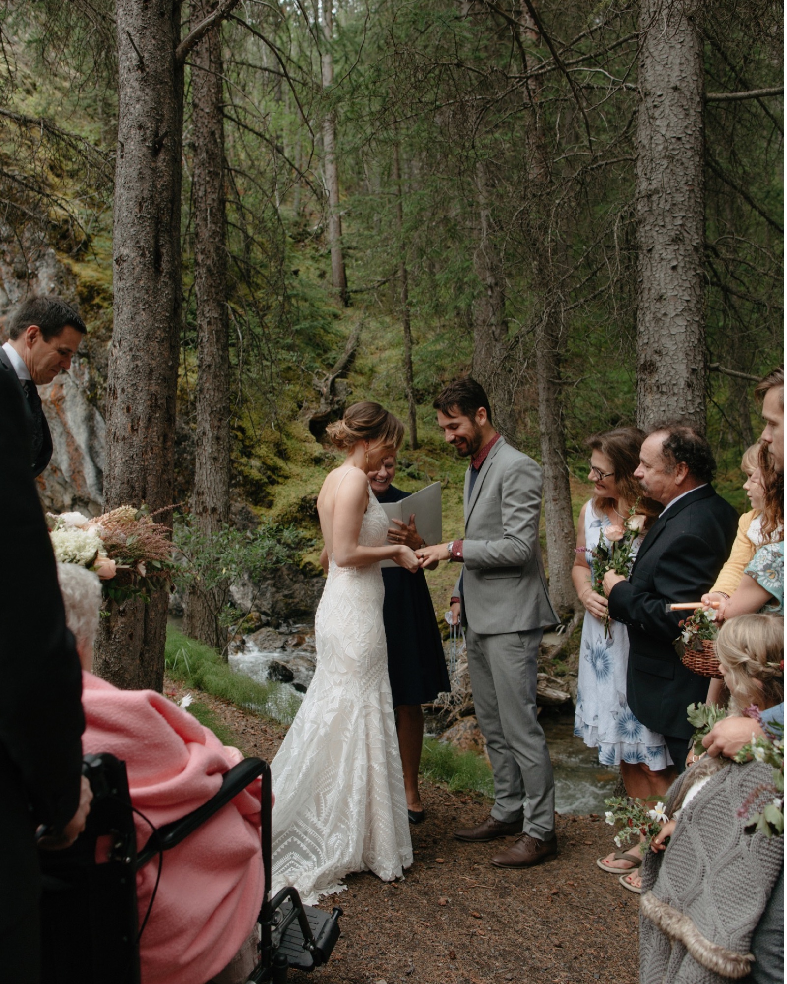 Ring exchange with a mossy backdrop at a Banff family-only wedding ceremony