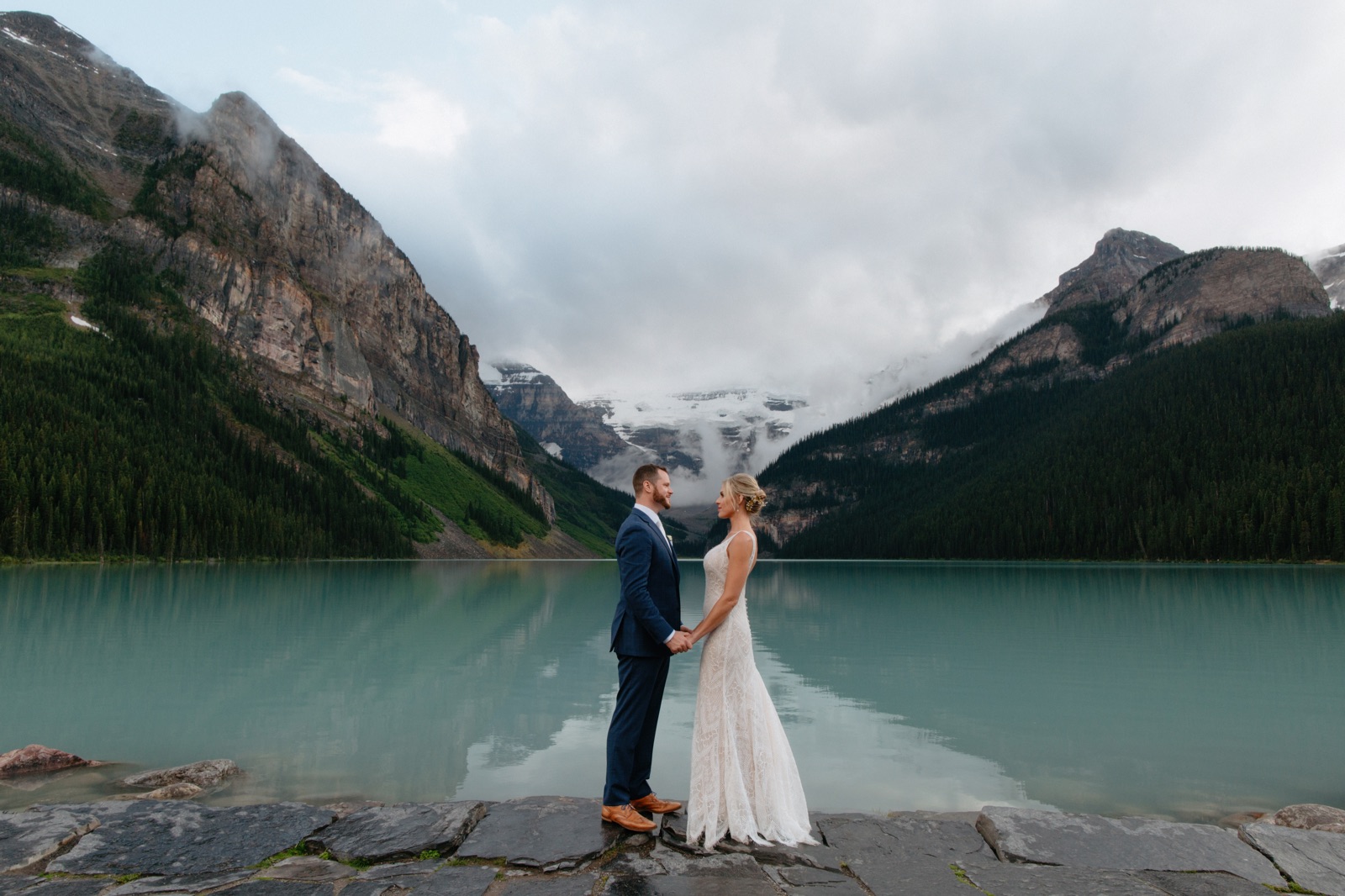 Wedding portraits on the steps at Lake Louise overlooking the Victoria Glacier