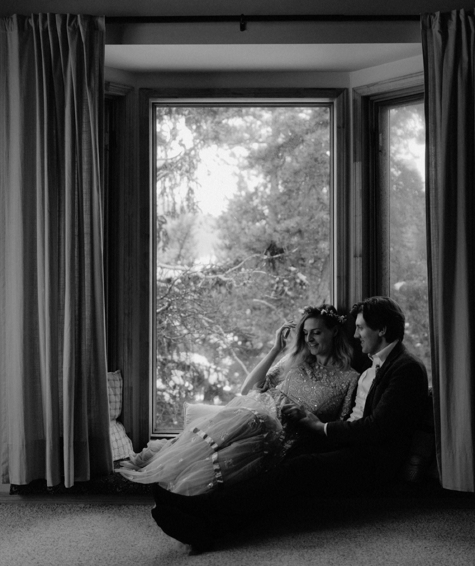 Eloping couple cuddling in the hummingbird room at Engadine Lodge