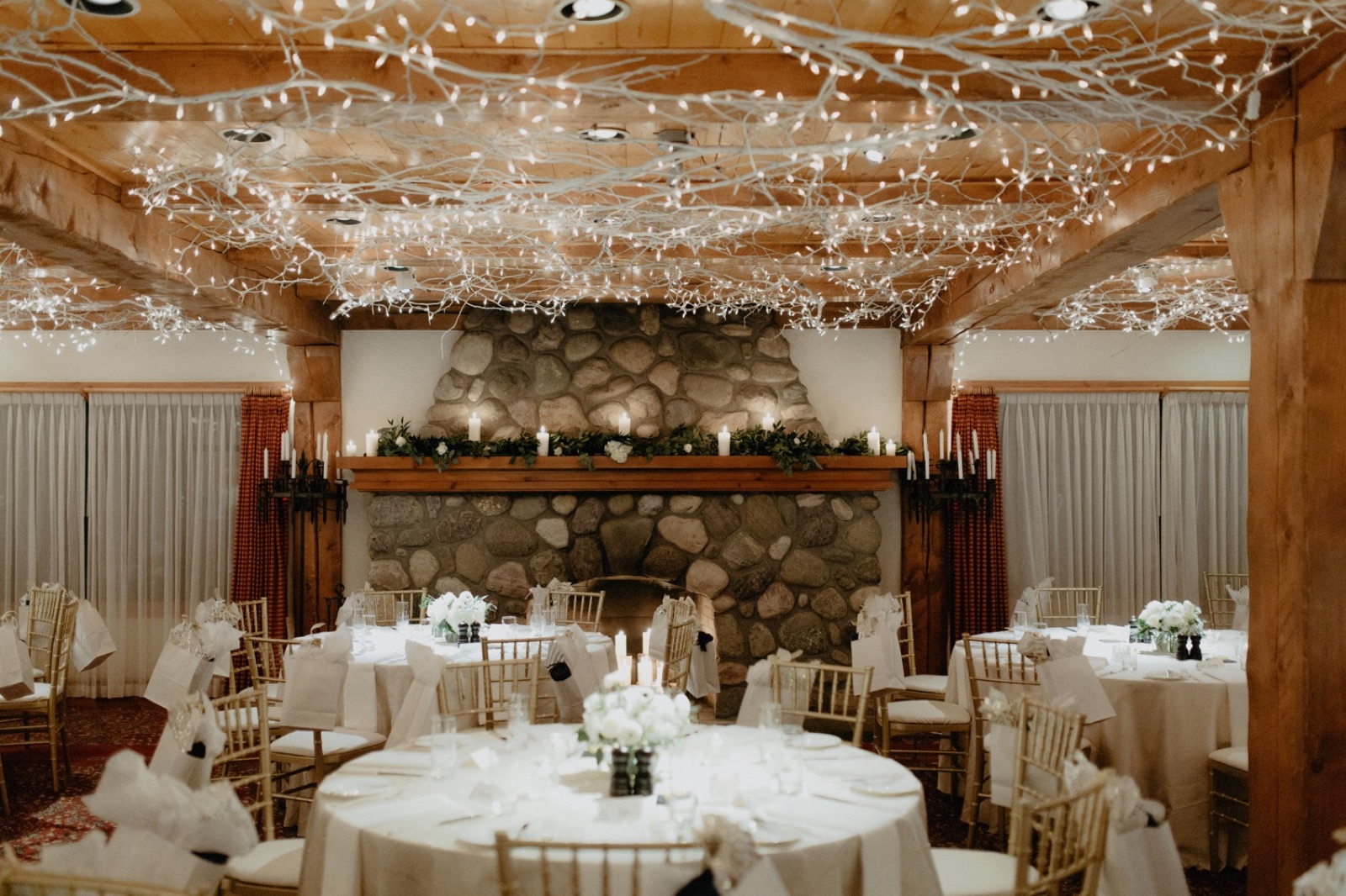 A winter wedding reception layout with gold chevalier chairs in Lake Louise