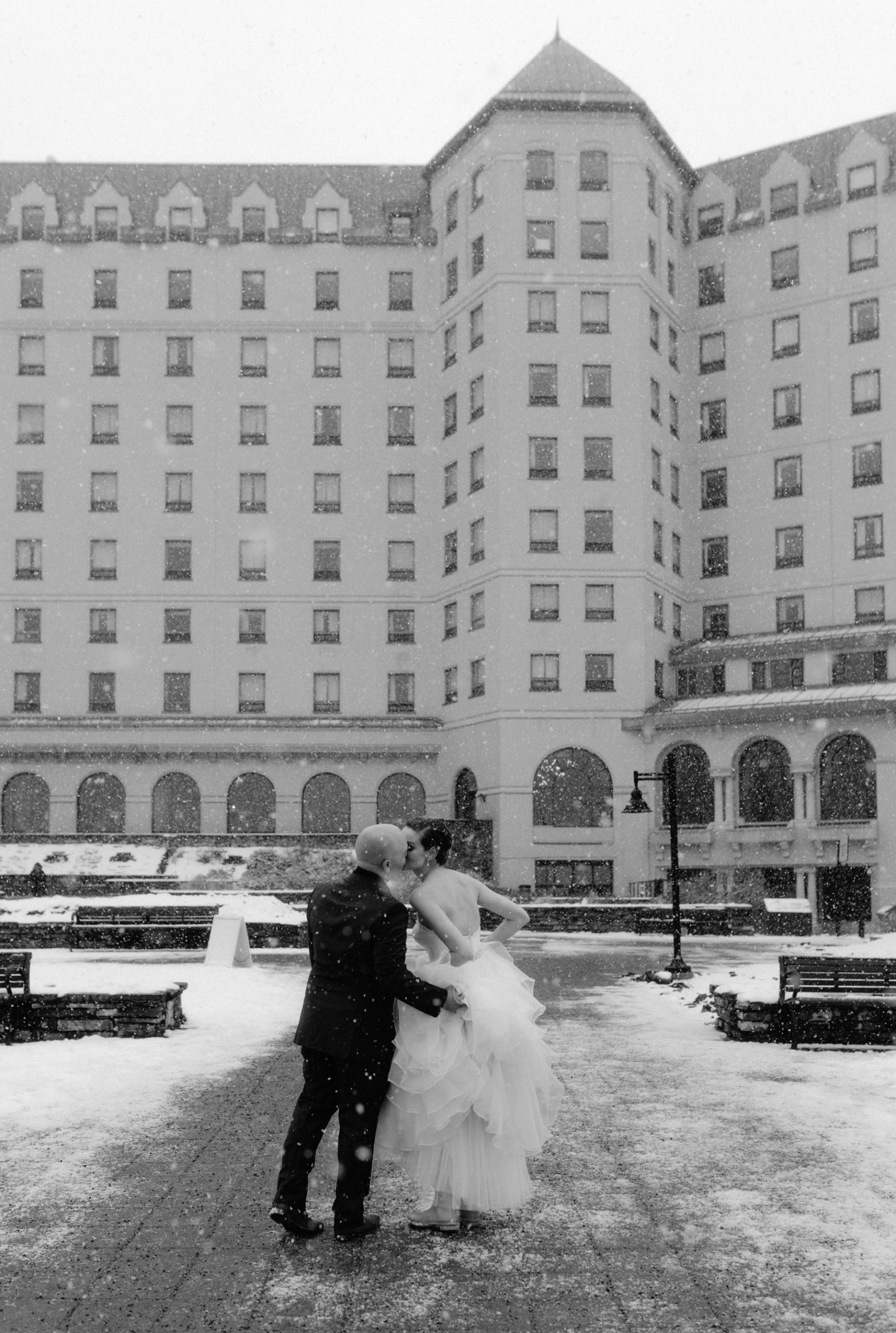 Winter wedding couple entering the Chateau Lake Louise from the lakeside entrance