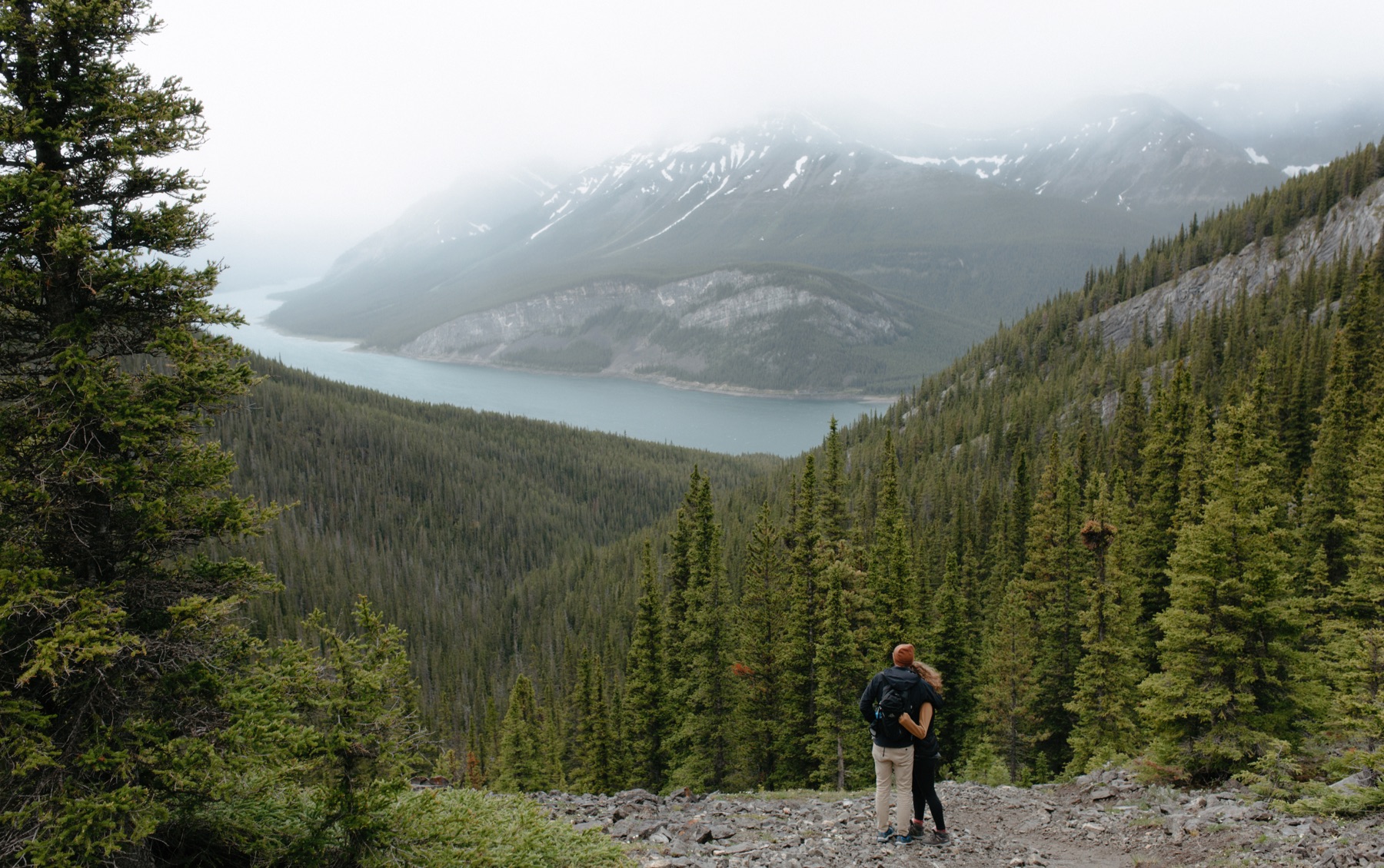 Overlook of Spray Lakes in Kananskis with couple embracing