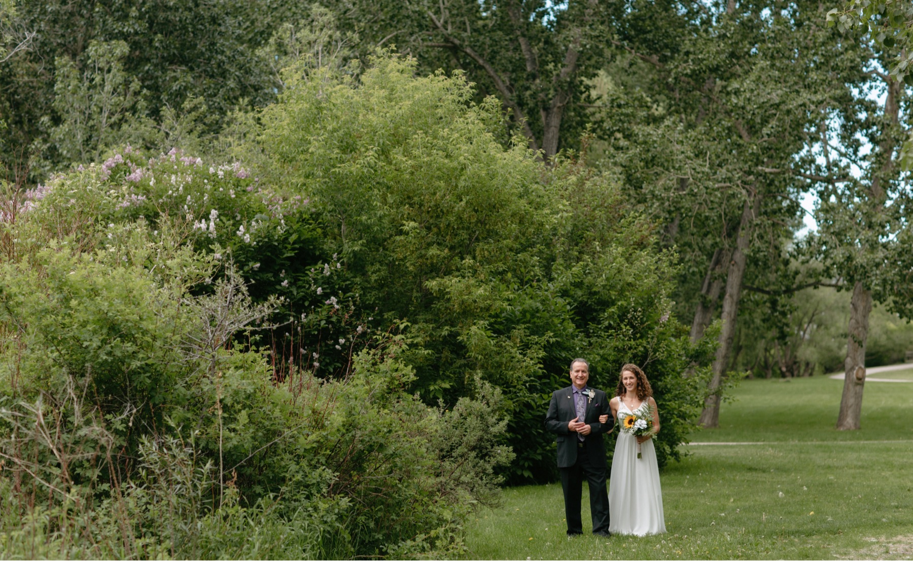 Bride and her father waiting in a secluded part of Confederation Park for the ceremony