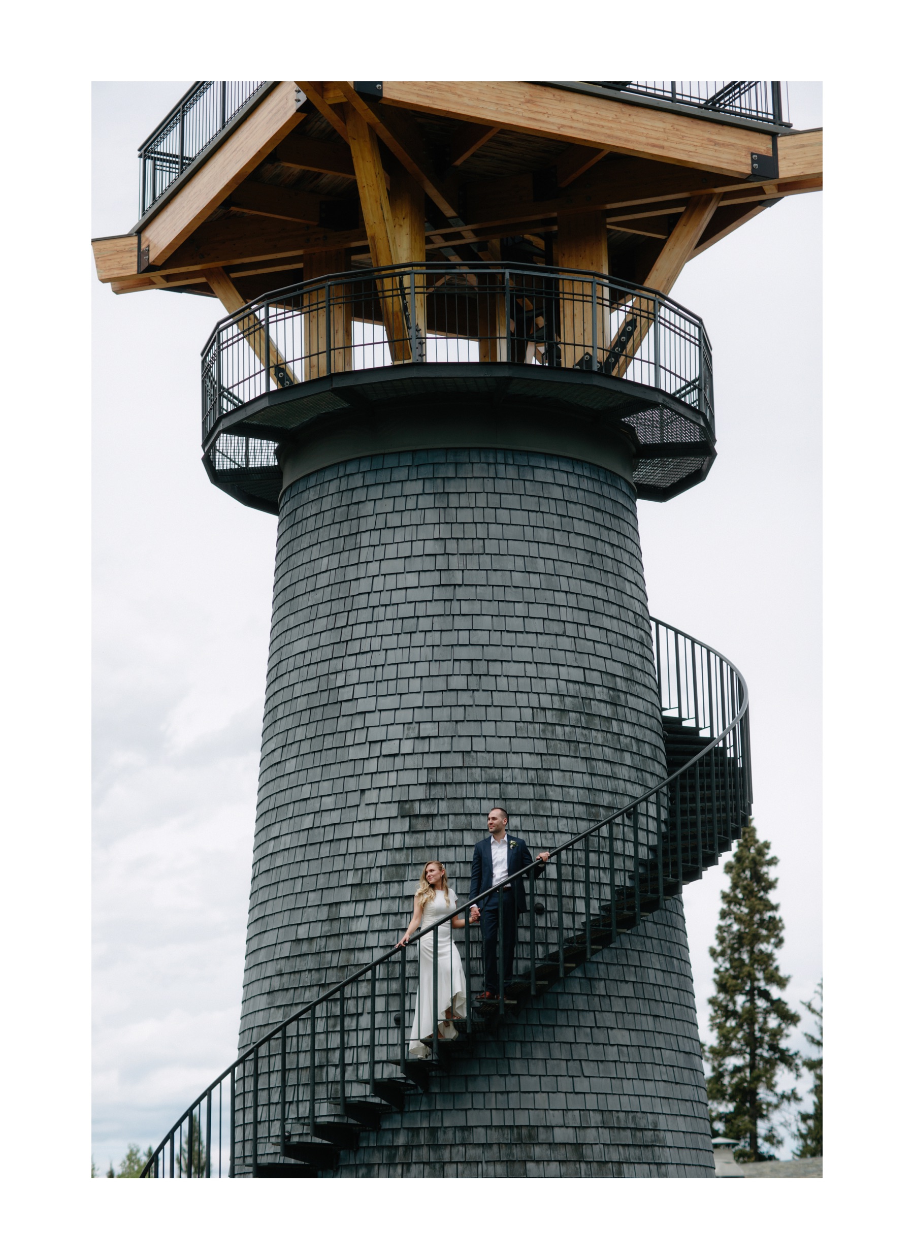 Bride and groom standing on circular staircase at Azuridge Estate blue shingled tower