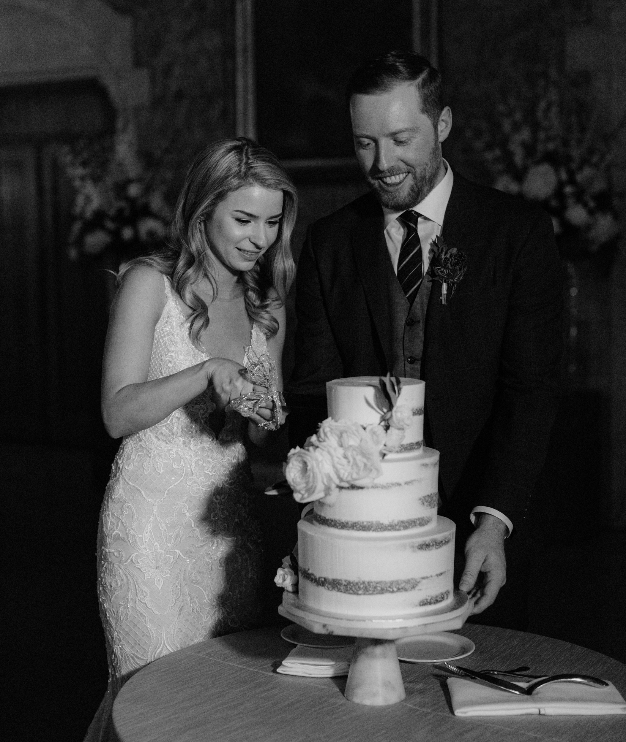Couple cutting their cake from Kake by Darci at the Banff Springs in black and white
