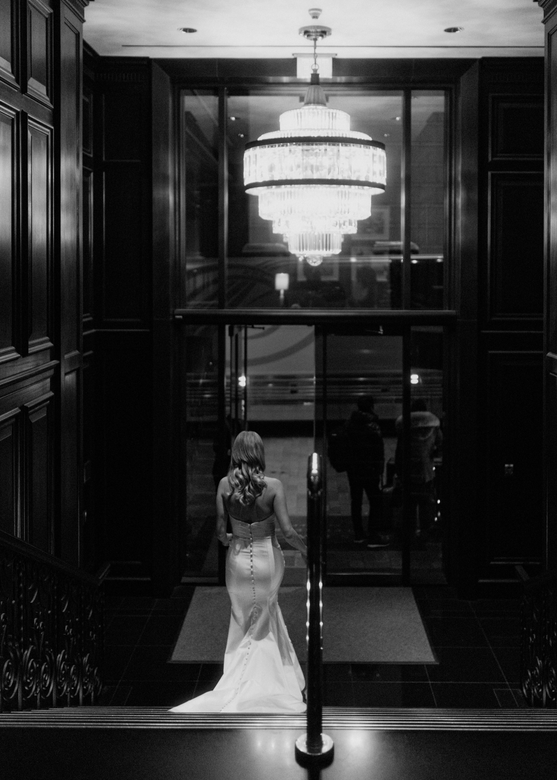 Bride with wavy hair descending the steps in front at the Hotel Georgia in Vancouver, British Columbia