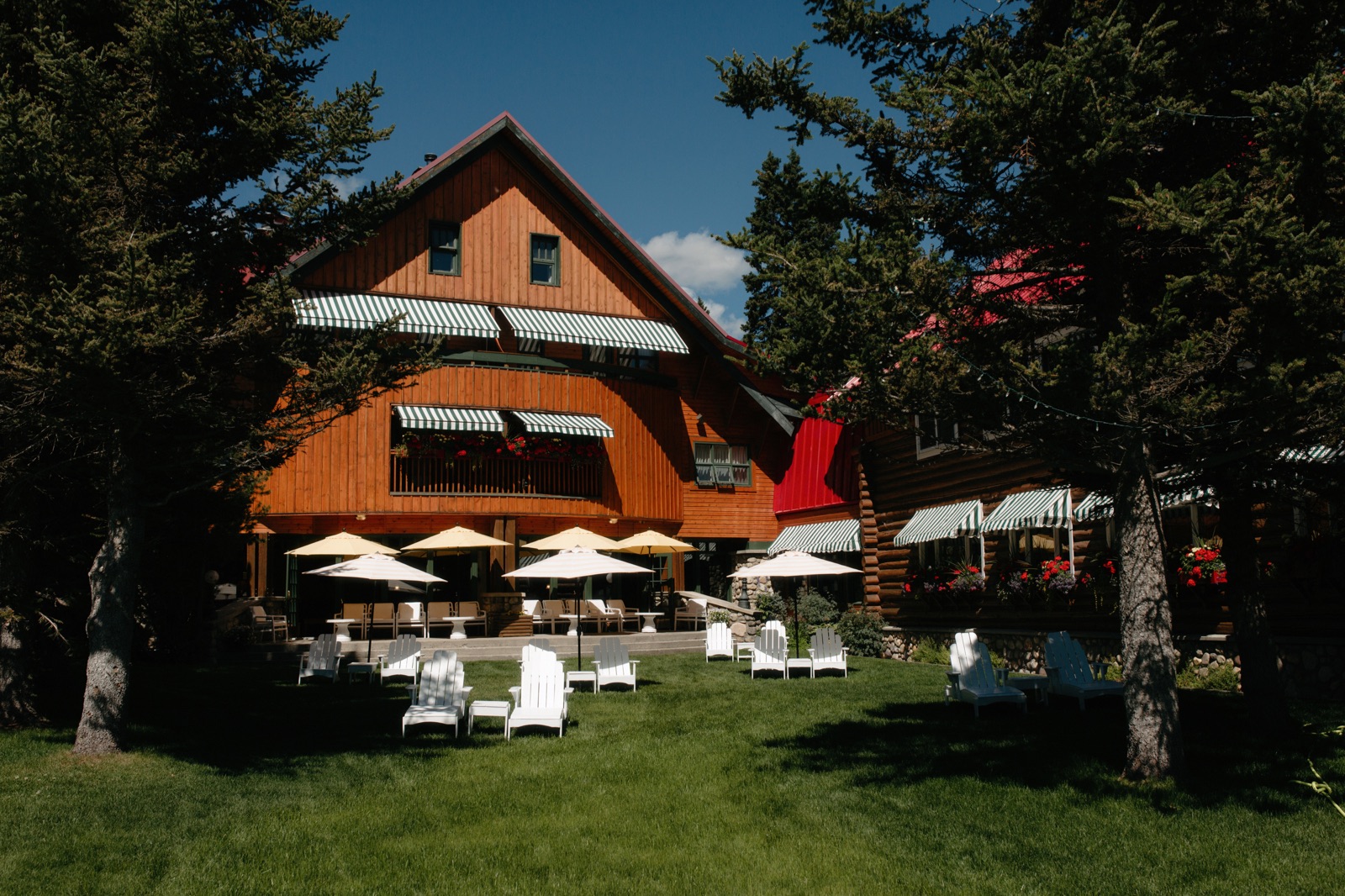 The lounge and sun space at the historic Post Hotel in Lake Louise with green and white striped awnings