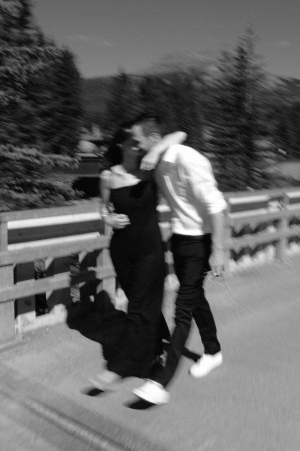 Couple embracing with her arm over his shoulder as they walk from their Banff elopement