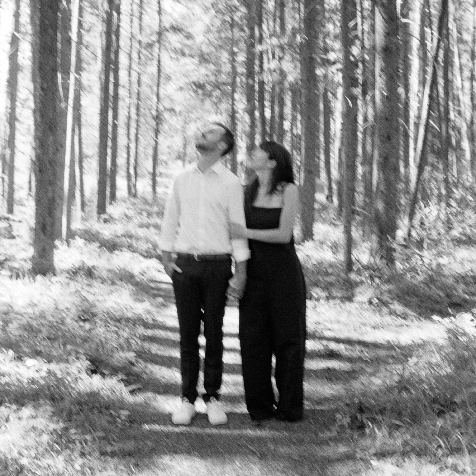 Lake Louise elopement couple embracing in a forest behind the Post Hotel as shot on black and white Ilford film