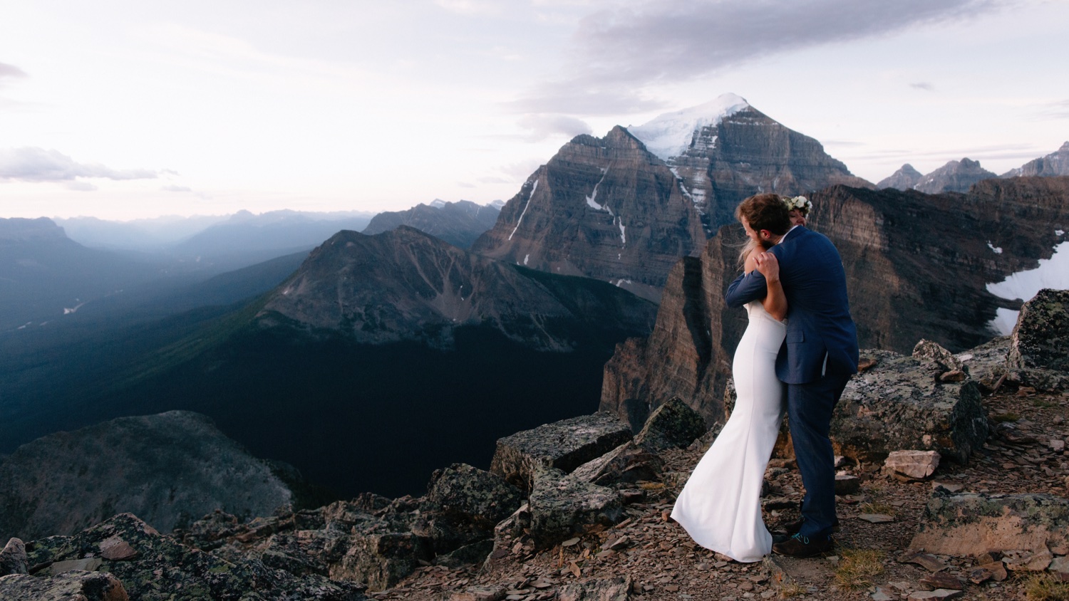 Newly eloped couple embracing looking down the Bow Valley towards Mount Temple