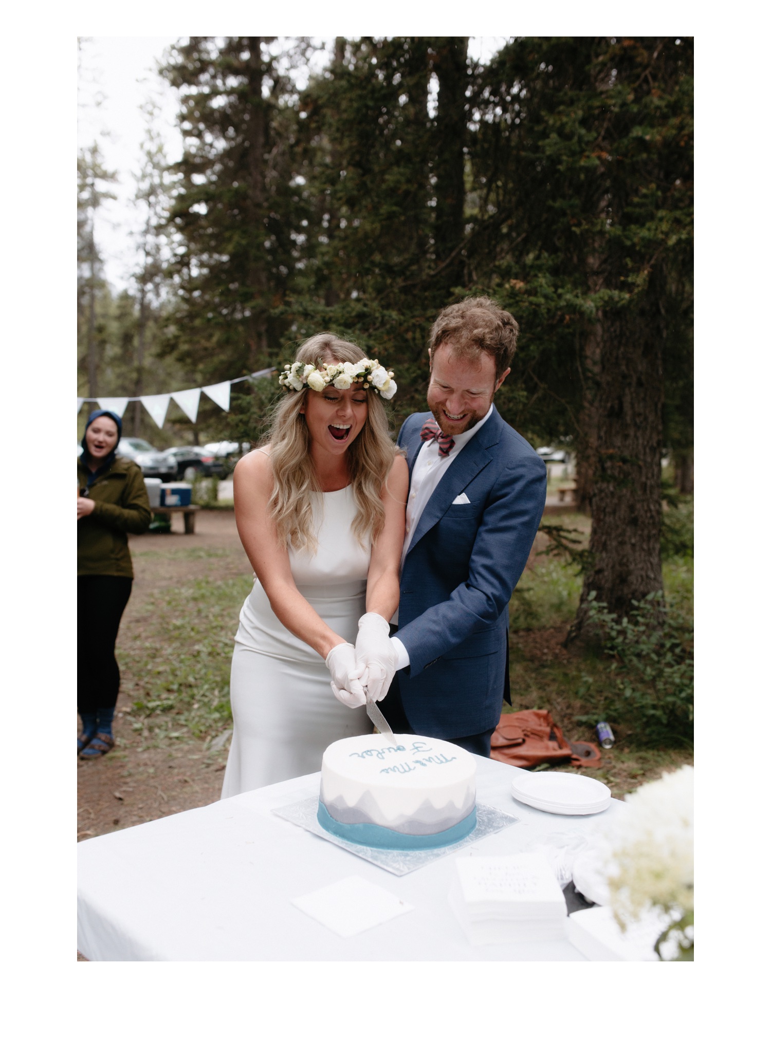 Couple cutting their homemade cake wearing white gloves at the Fairview Picnic area in Banff
