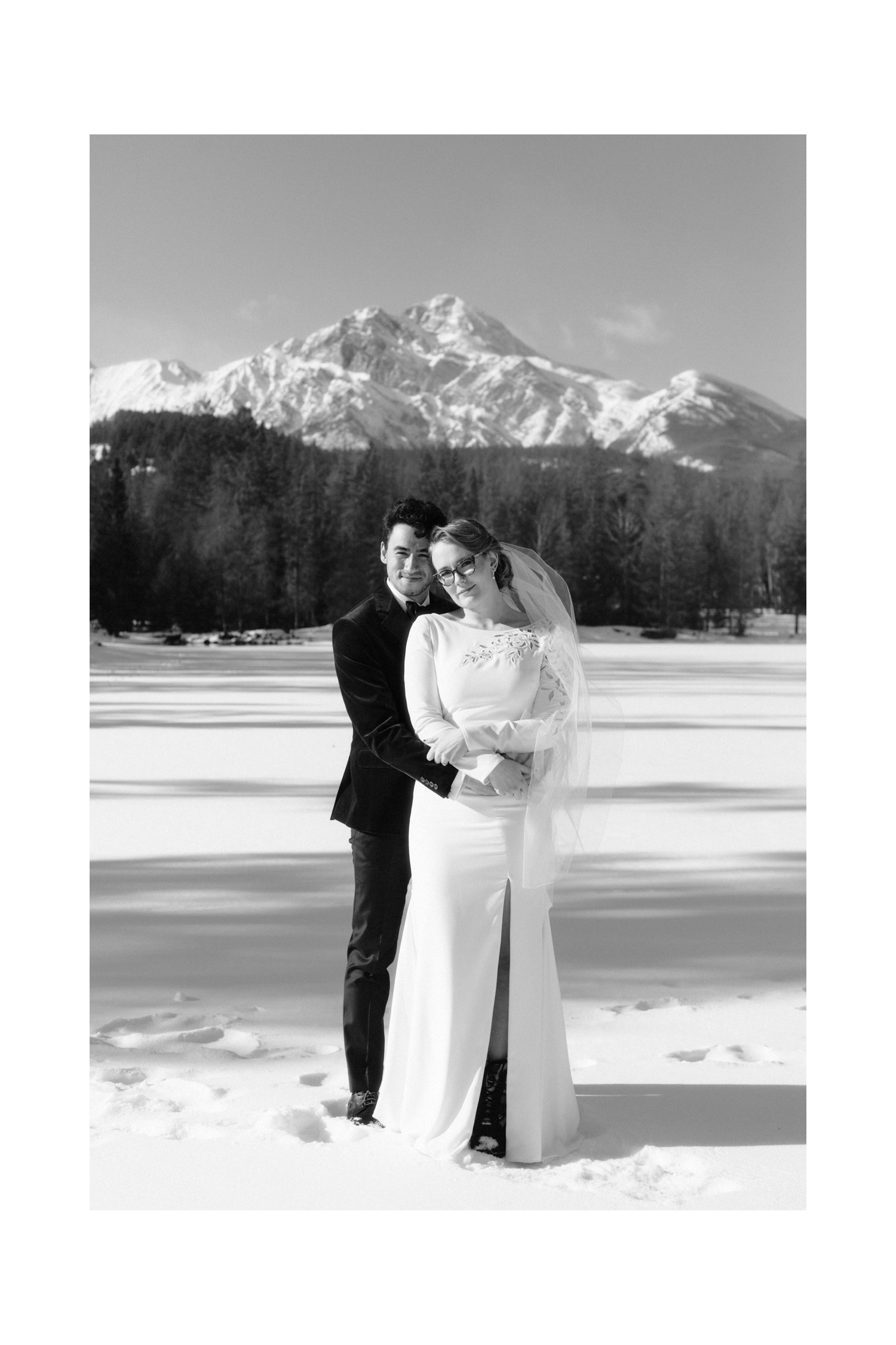 Classic wedding portraiture on a frozen lake in Canada overlooking Pyramid Mountain