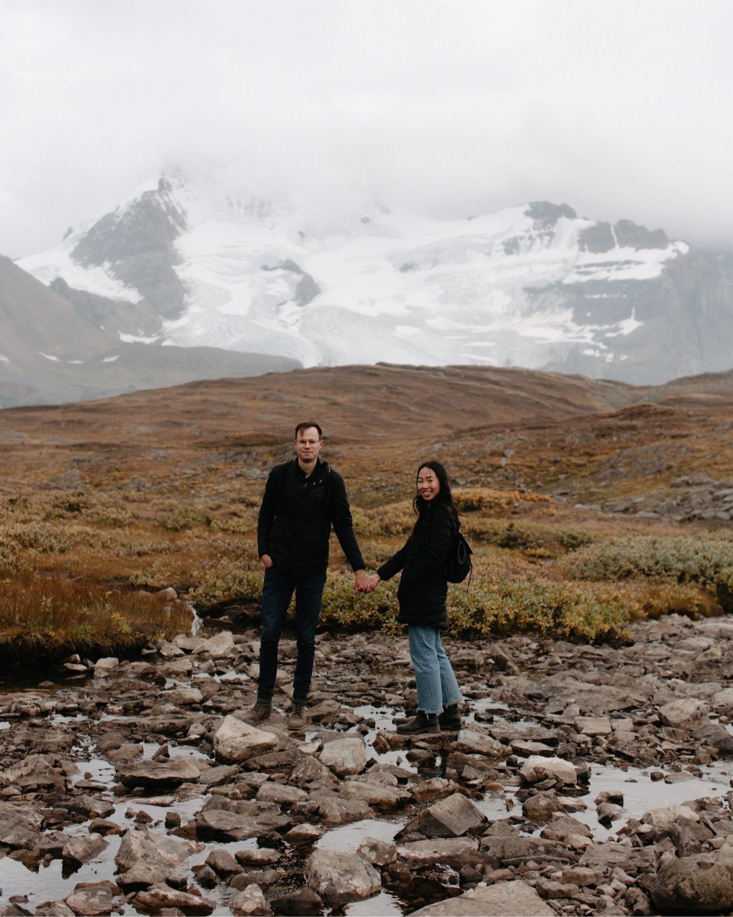 Couple smiling at the camera with a backdrop of Mount Athabasca