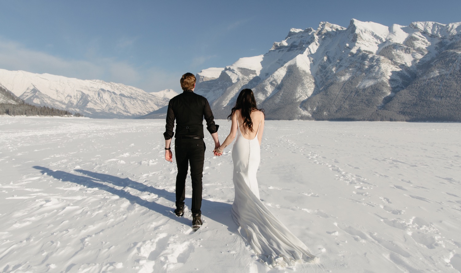 Wedding photography session on frozen Lake Minnewanka in winter
