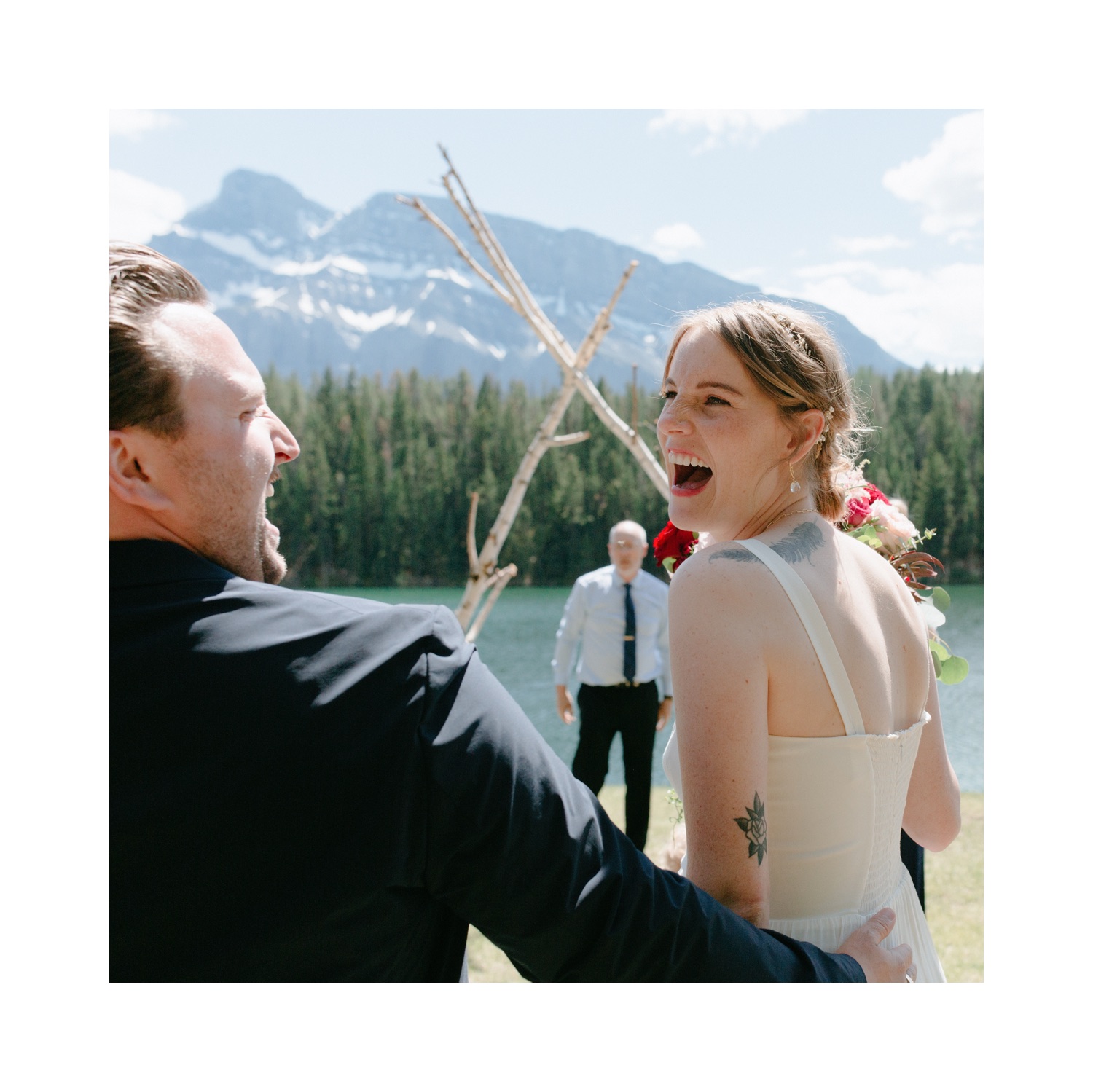 Soon to be married couple embrace and look at each other with absolute joy and excitement after her father set up a birch altar in Banff