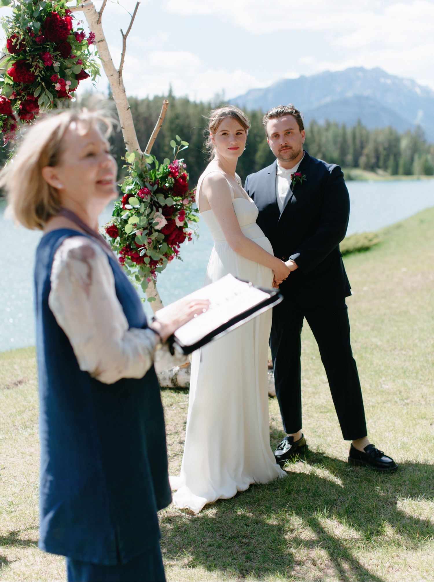 Bride wearing Reformation dress and groom in Hugo Boss suit for their Johnson Lake ceremony