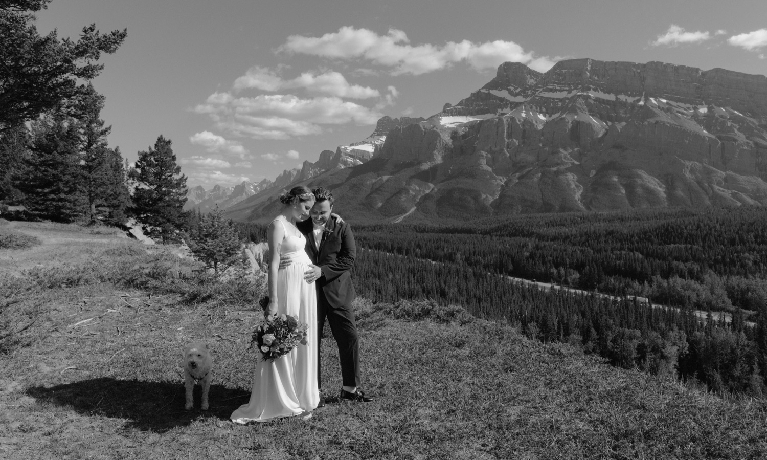 Pregnant wedding couple overlooking Mount Rundle in Banff National Park for candid wedding portraits