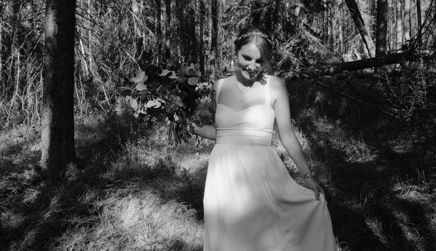 Bride dancing in dappled light of a forest