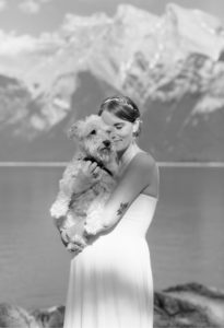 Bride embracing her elderly white miniature schnauzer