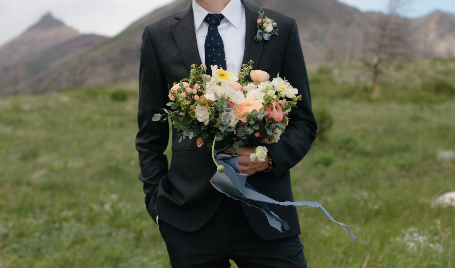 Meadow and Vine Floral bouquet for a Waterton wedding with soft warm hues and blue ribbon