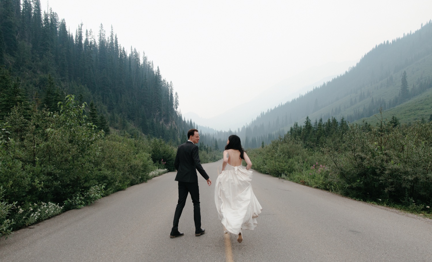 Eloped couple running down the Icefields Parkway near Jasper
