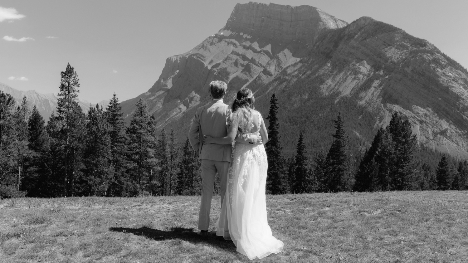 Couple embracing after their ceremony and reception at Tunnel Mountain Reservoir overlooking Mount Rundle