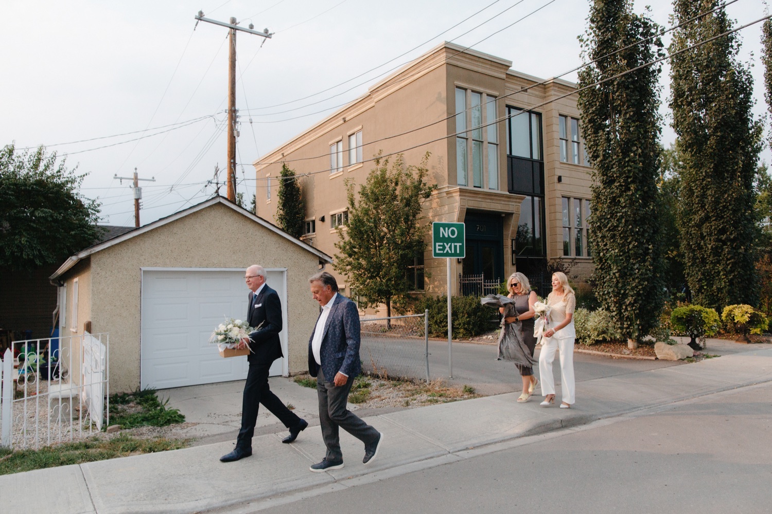 Group of four walking along Inglewood sidewalks to their Rouge Restaurant reception